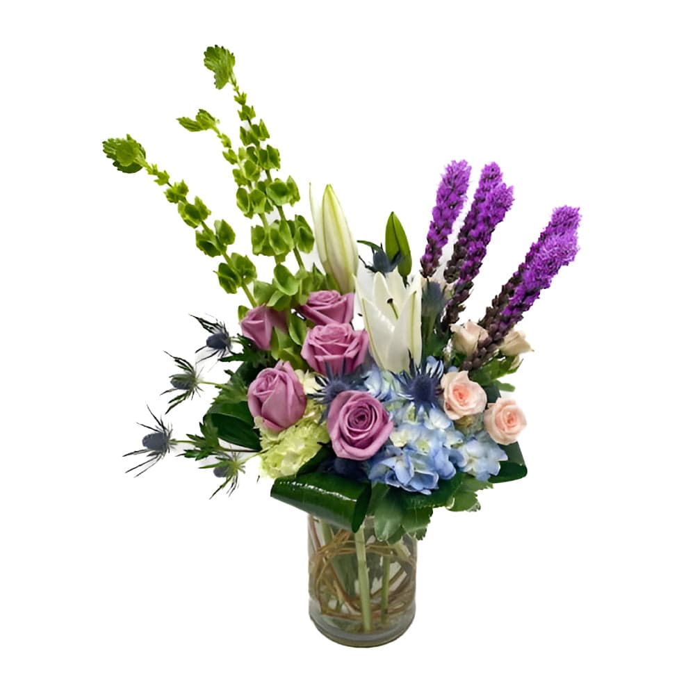 A vibrant floral arrangement featuring roses, lilies, and colorful seasonal blooms in a chic vase.