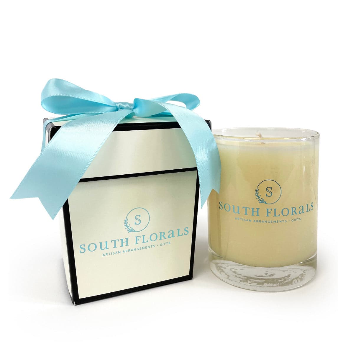 Artisan candle from South Florals, elegantly packaged in a black box with a light blue ribbon for gifting.